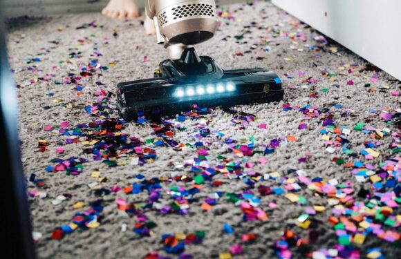 a person using a vacuum to clean a carpet